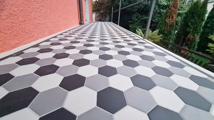 Auf dem Vorplatz des Hauses verlegt die Hänni AG hexagonale Feinsteinzeugplatten in drei Farben – Weiss, Anthrazit und Schwarz. Der Aussenbelag weist ein geometrisches Design auf.