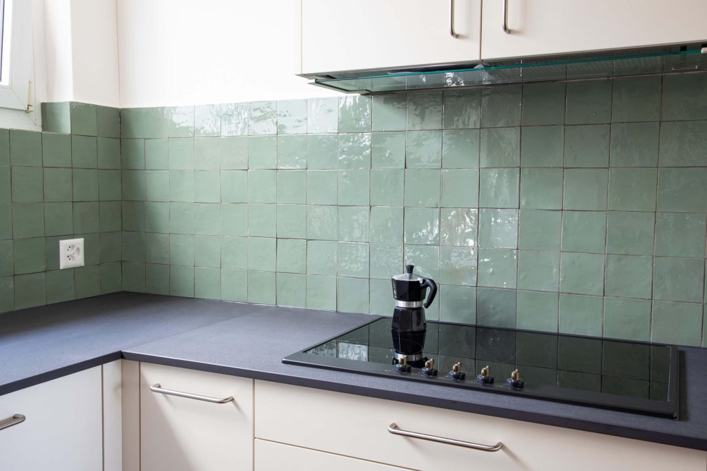 Grüne quadratische Zellige Platten als Küchenrückwand.